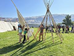 Image of three people demonstrating how to set up a teepee 