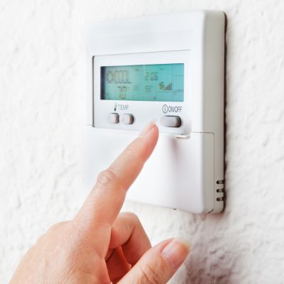 Person turning off programmable thermostat