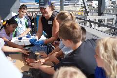 Image of children helping a fisheries worker dissect a salmon