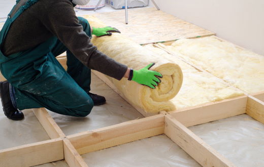 person rolling out insulation batting